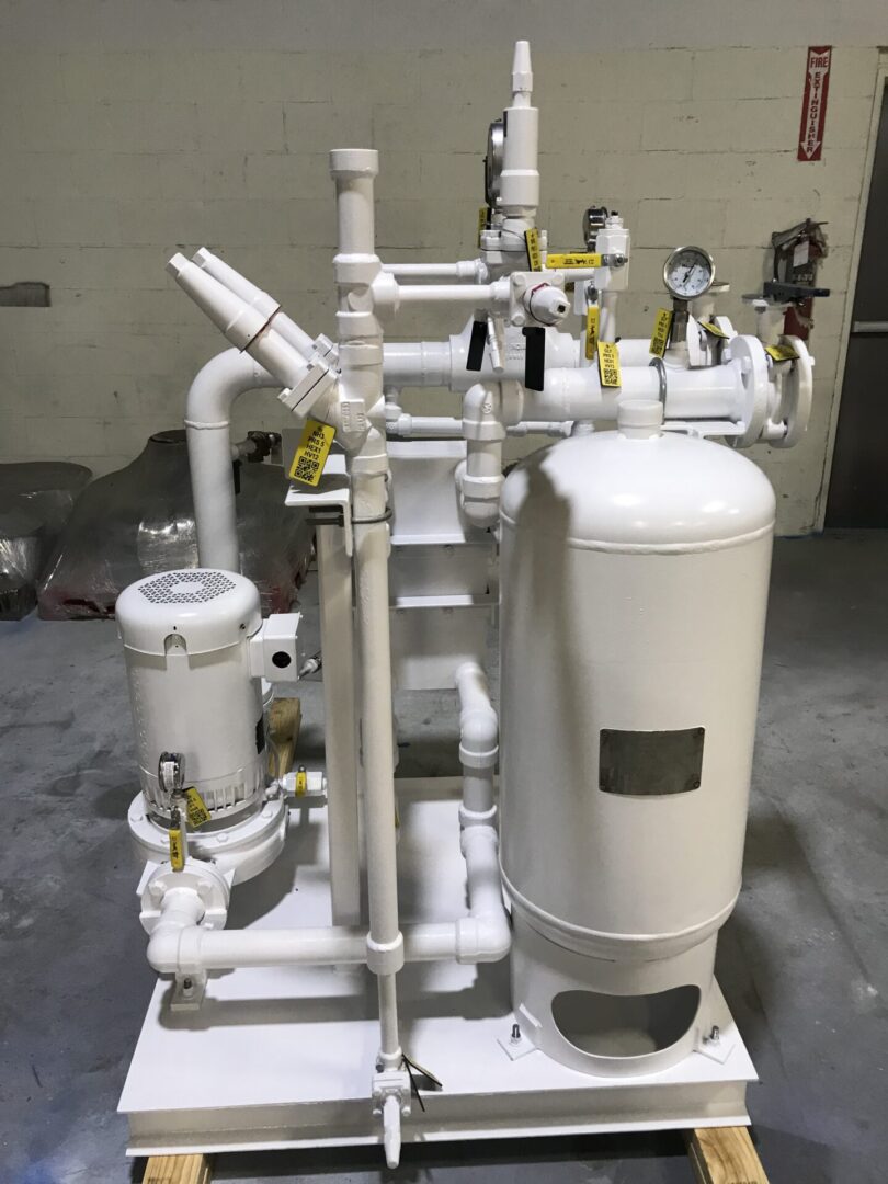 A white tank sitting next to pipes and valves.