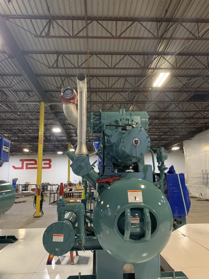 A large machine in a warehouse with other machinery.