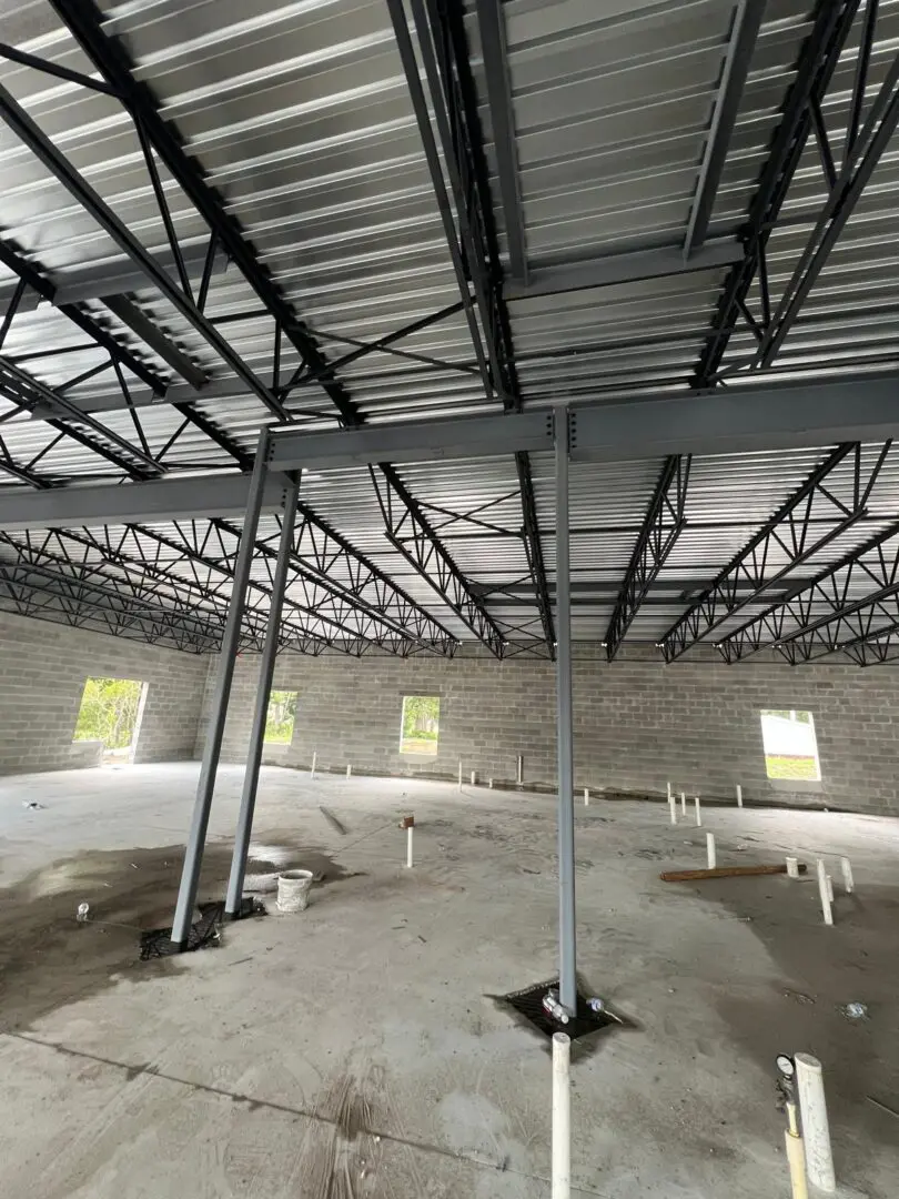 A large room with metal roof and concrete floors.