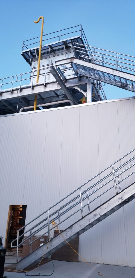 A large white building with stairs going up it.