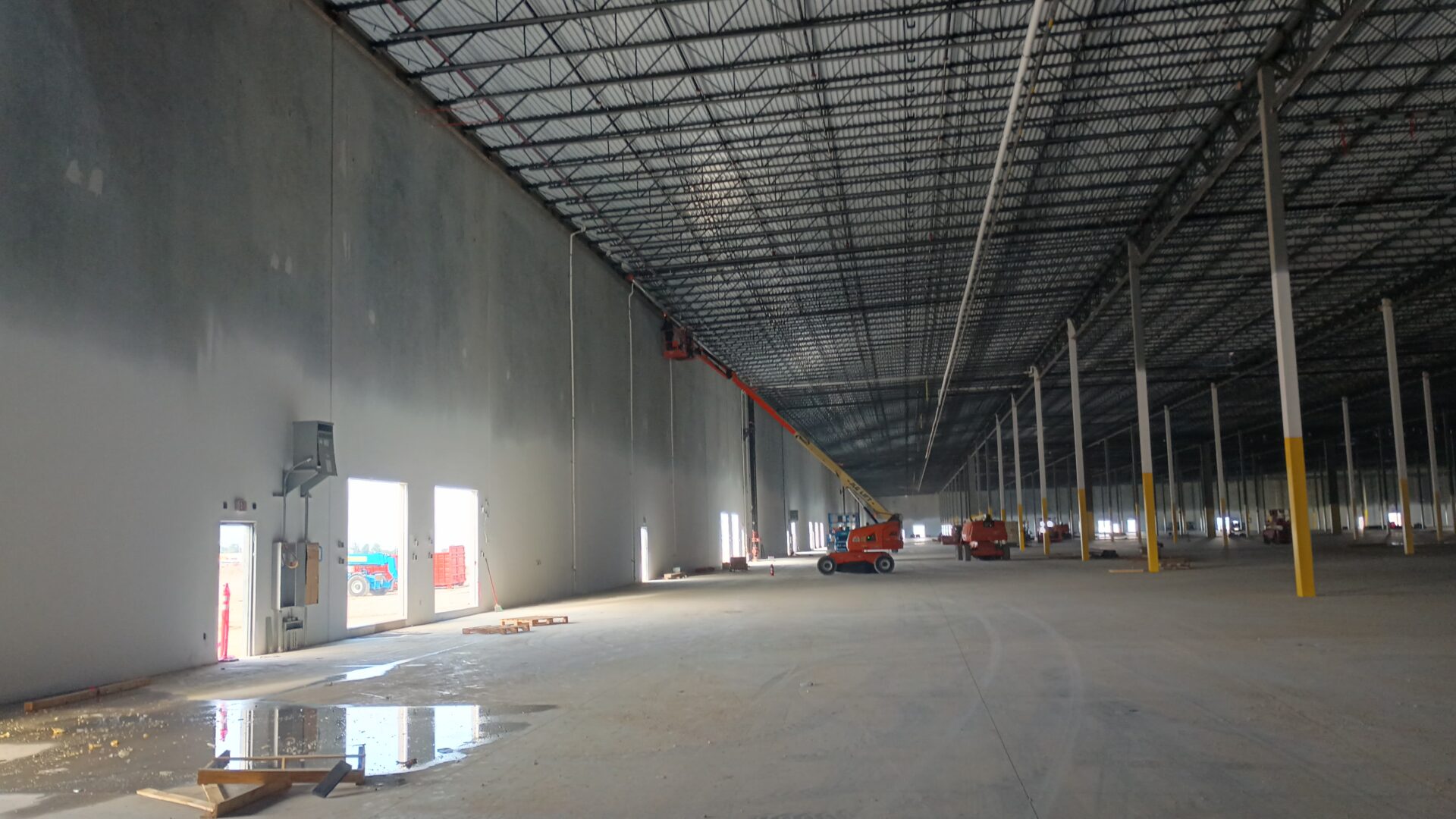 A large warehouse with a crane in the middle of it.